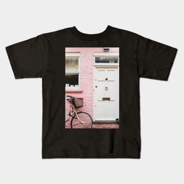 Bicycle against a pink wall Kids T-Shirt by mooonthemoon